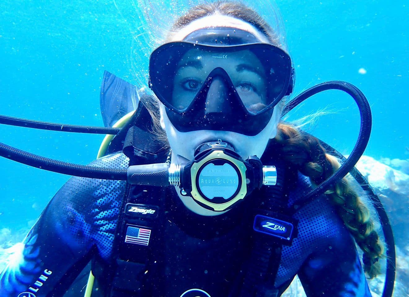 Jessica Hanjora scuba diving in crystal-clear blue water
