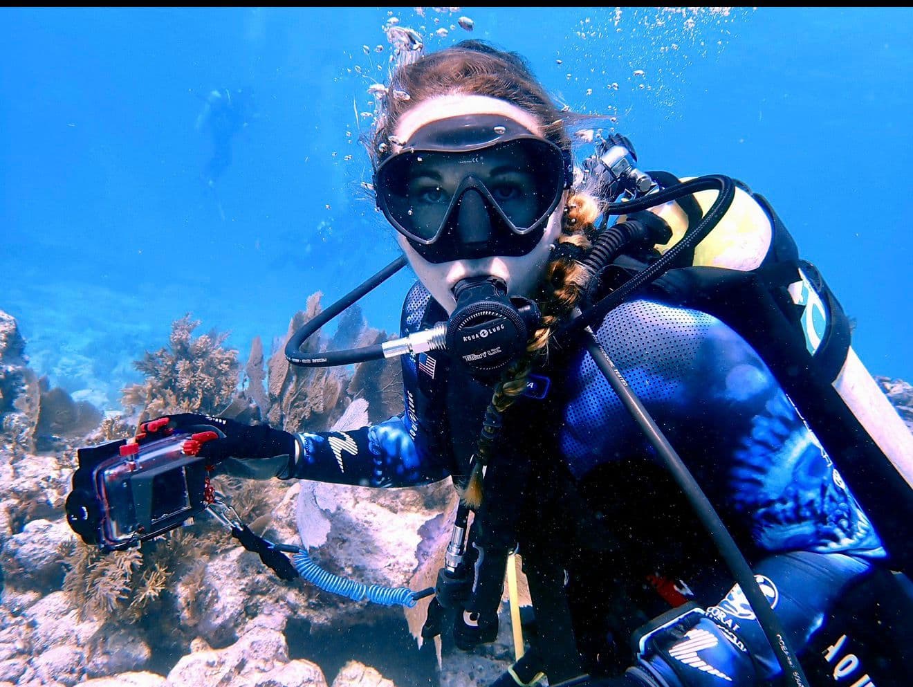 Jessica diving with camera on a coral reef